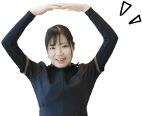 頭の上で両腕で丸を作る女性スタッフ