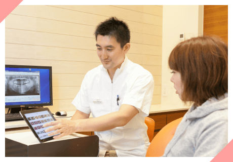 レントゲン画像を表示しタブレットで患者に説明する矯正歯科医