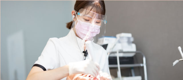 患者の口元を処置する女性スタッフ