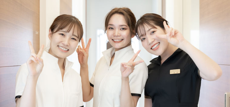 ピースサインで笑顔を見せる女性スタッフ3人