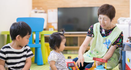 キッズルームで子どもたちと遊ぶ保育士