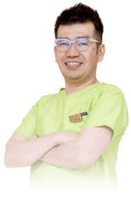 腕を組んでほほえむ院長