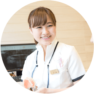 歯列模型を手にする女性スタッフ