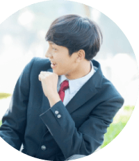 制服姿で笑顔を見せる男子学生