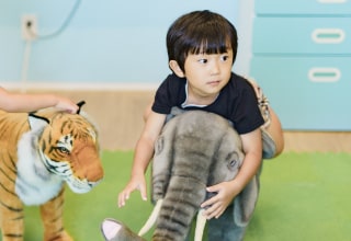 ゾウのぬいぐるみに乗る男の子