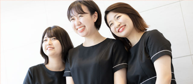 寄り添って笑う女性スタッフ3名